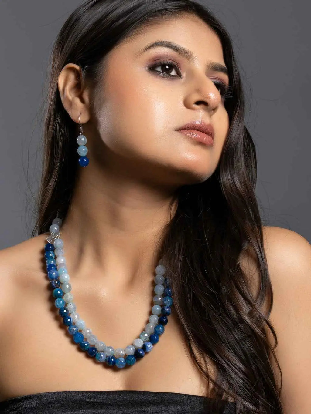 Handmade onyx necklace set with multicolored beads in blue and gray tones, elegantly styled for modern wear