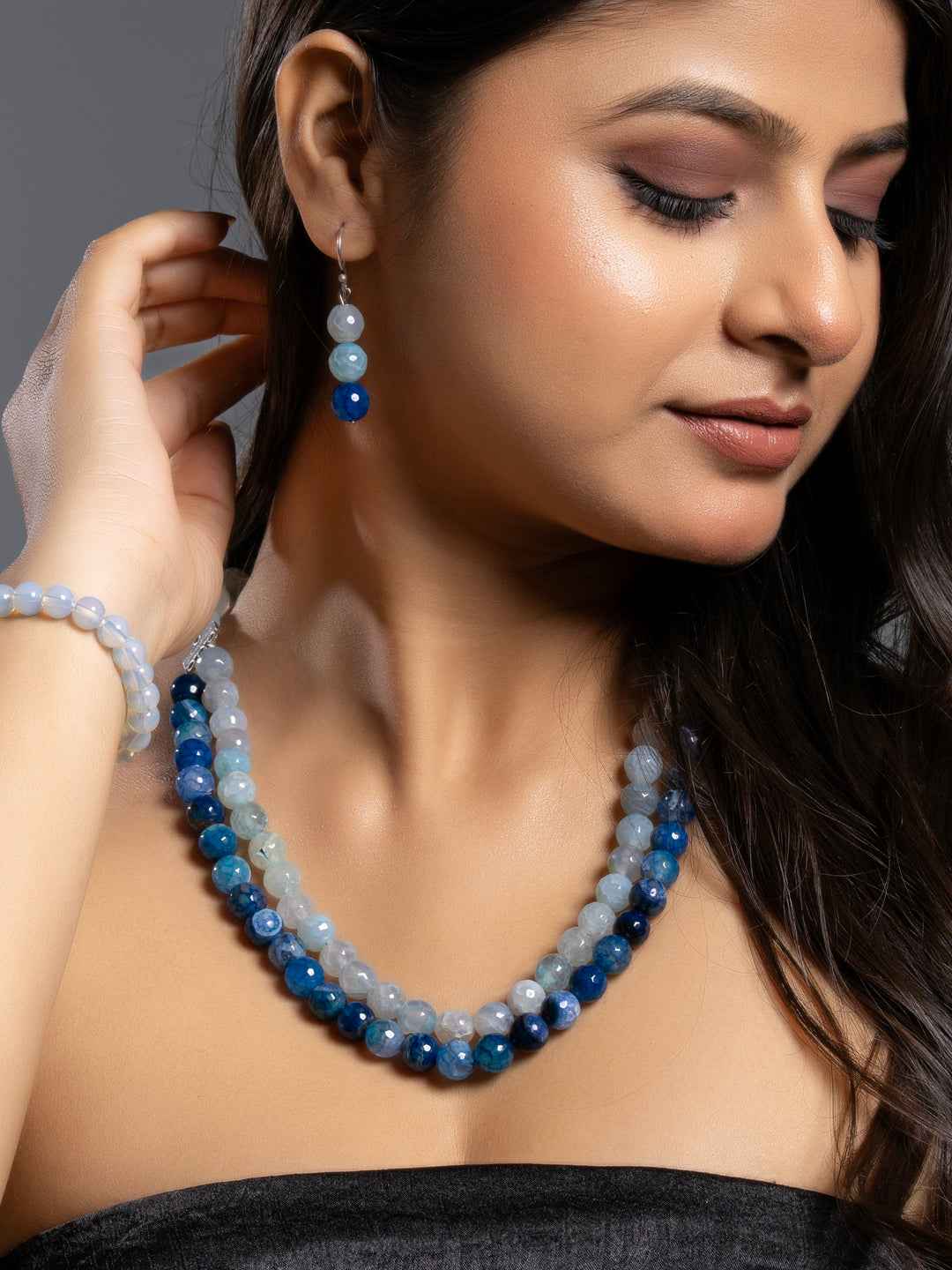 Handmade onyx necklace set with blue and gray beads, elegantly styled with matching earrings
