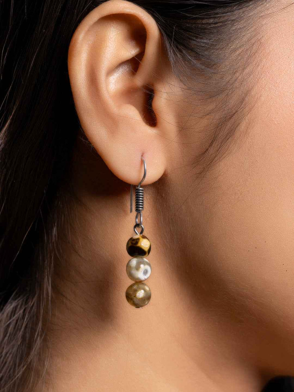 Handmade three-bead earring set featuring onyx, pearl, and gold tones in a stylish drop design