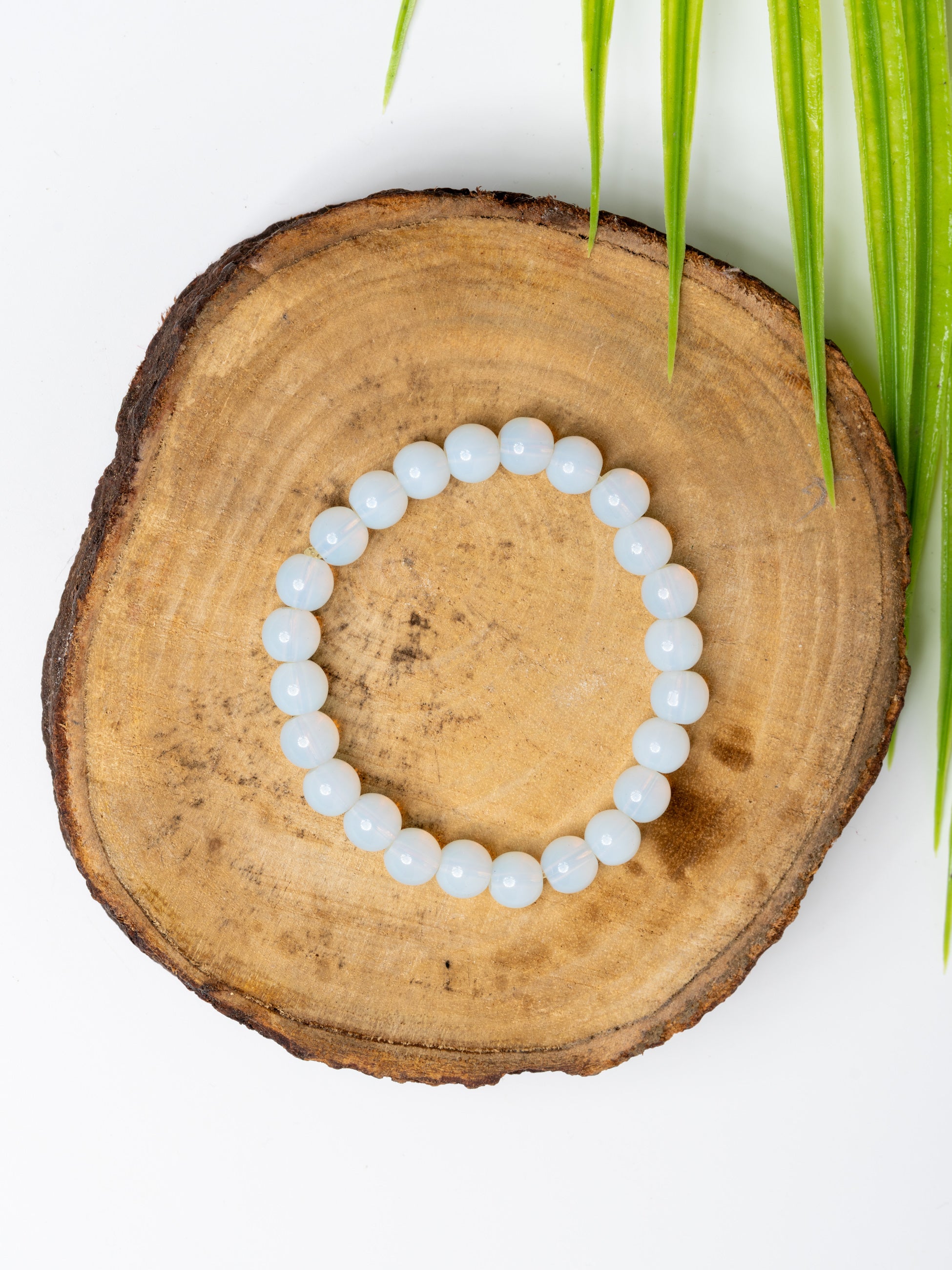 Opalite bracelet crafted by LOOK AND ADORN with a soothing, translucent finish on a natural wood display