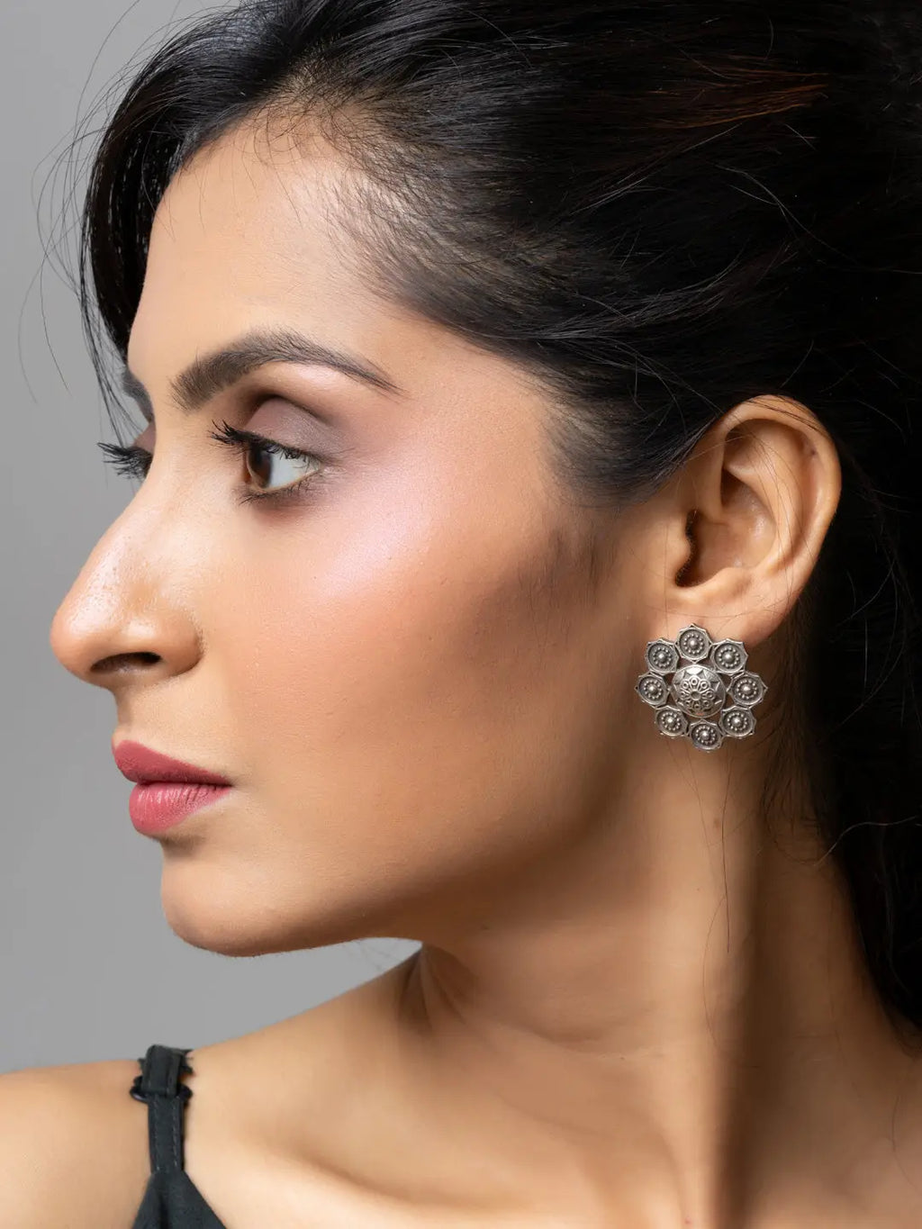 Close-up of woman wearing oxidised earrings from LOOK AND ADORN with floral design in oxidised silver