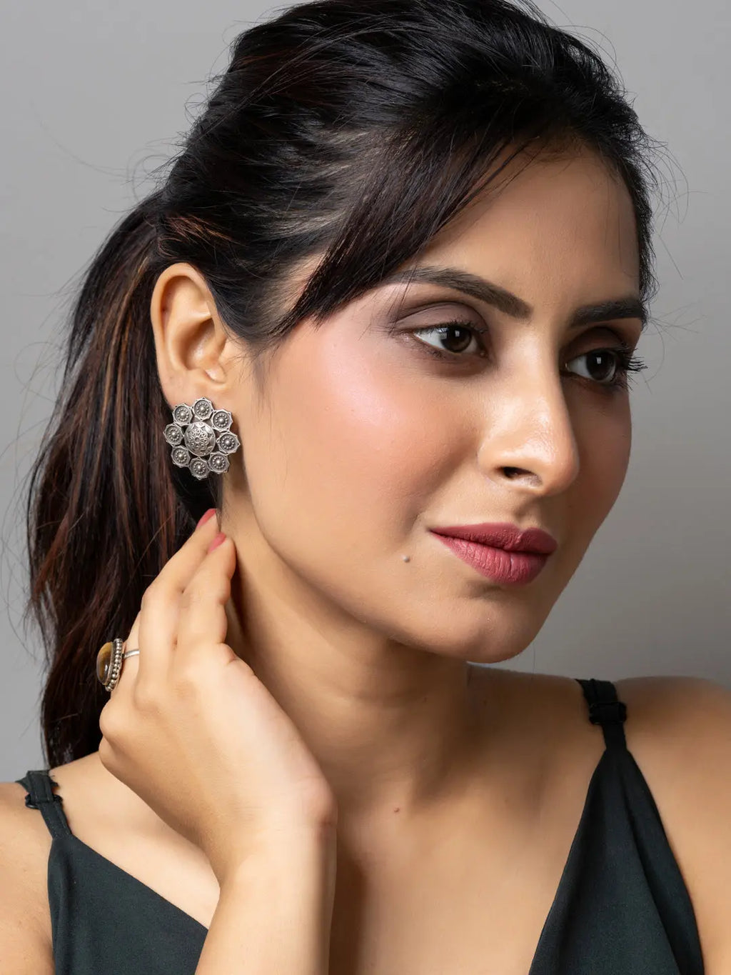 Woman wearing oxidised earrings with intricate floral design by LOOK AND ADORN