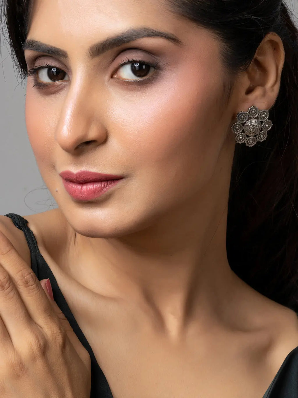 Woman wearing oxidised earrings with intricate floral design in oxidised silver by LOOK AND ADORN