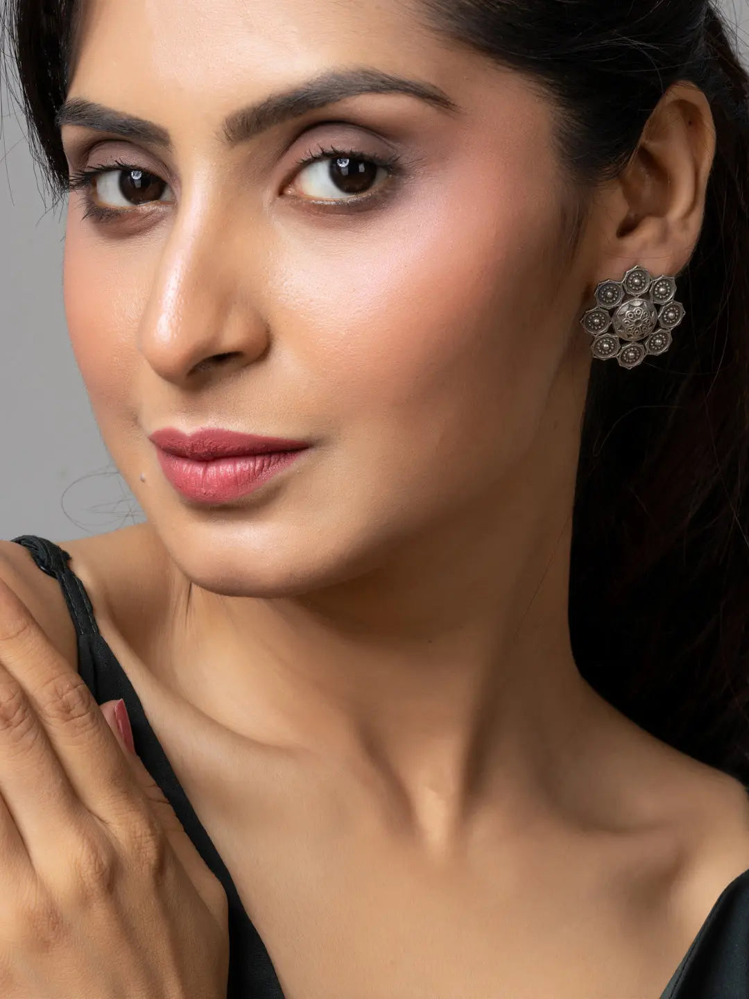 Woman wearing oxidised earrings with intricate floral design in oxidised silver by LOOK AND ADORN