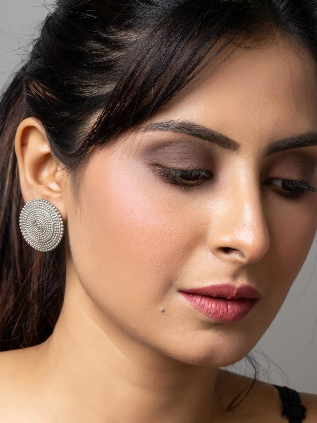 Close-up of woman wearing round oxidised earrings made of oxidised silver by LOOK AND ADORN