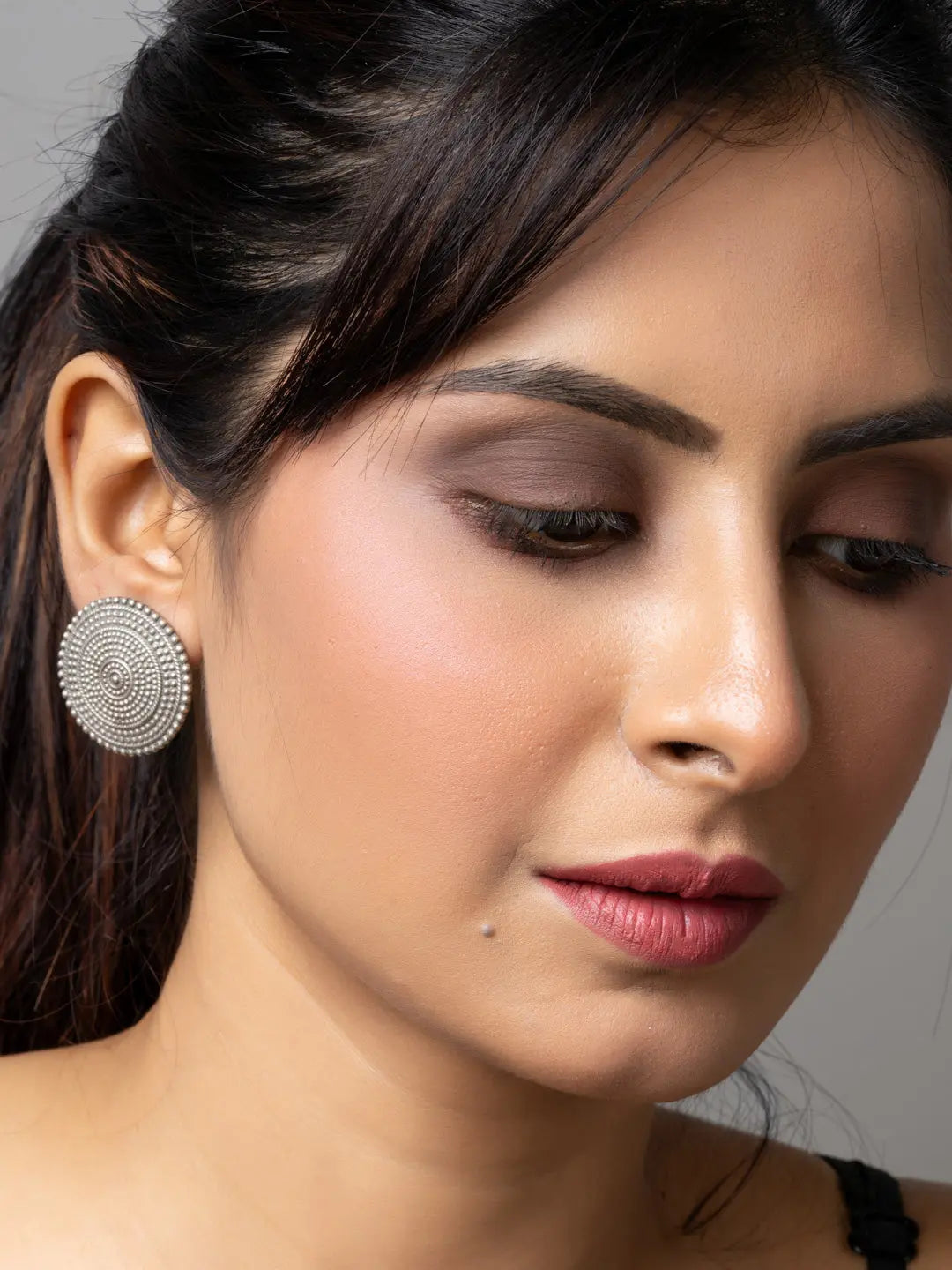 Close-up of woman wearing round oxidised earrings made of oxidised silver by LOOK AND ADORN