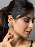 Close-up of woman wearing round oxidised earrings in oxidised silver with intricate design