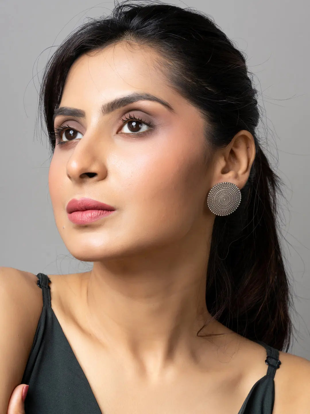 Close-up of woman wearing round oxidised earrings from LOOK AND ADORN with intricate design