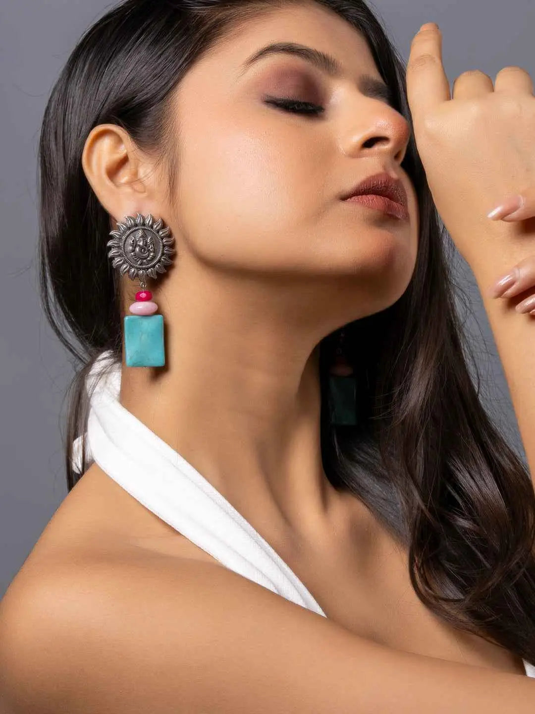 Oxidised earrings featuring a silver sun motif paired with turquoise and pink geometric accents