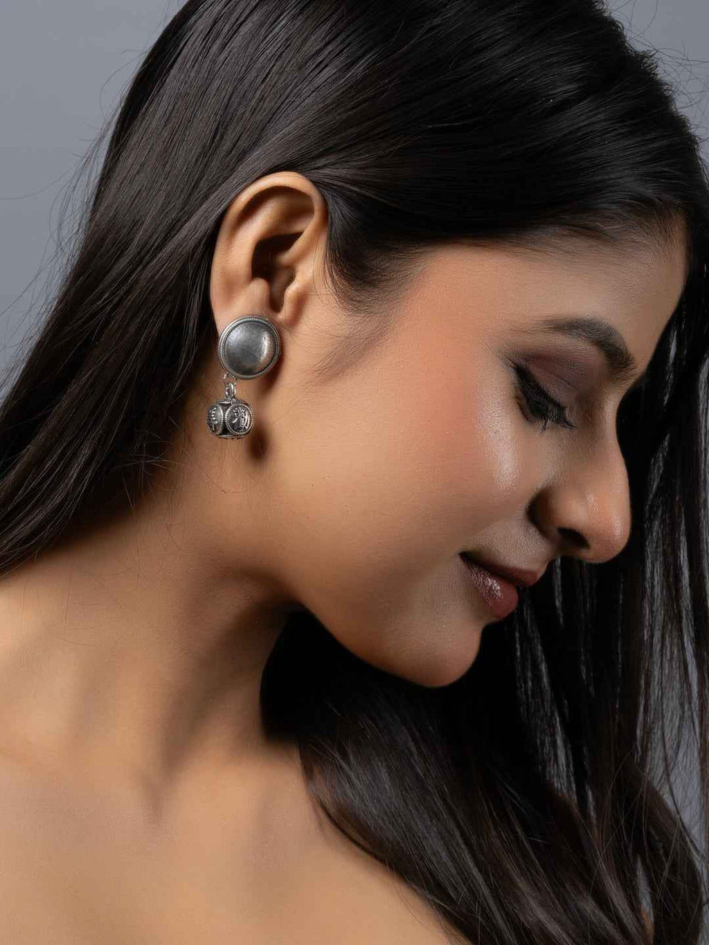 Oxidised earrings featuring a round design with floral detailing in dark gray color