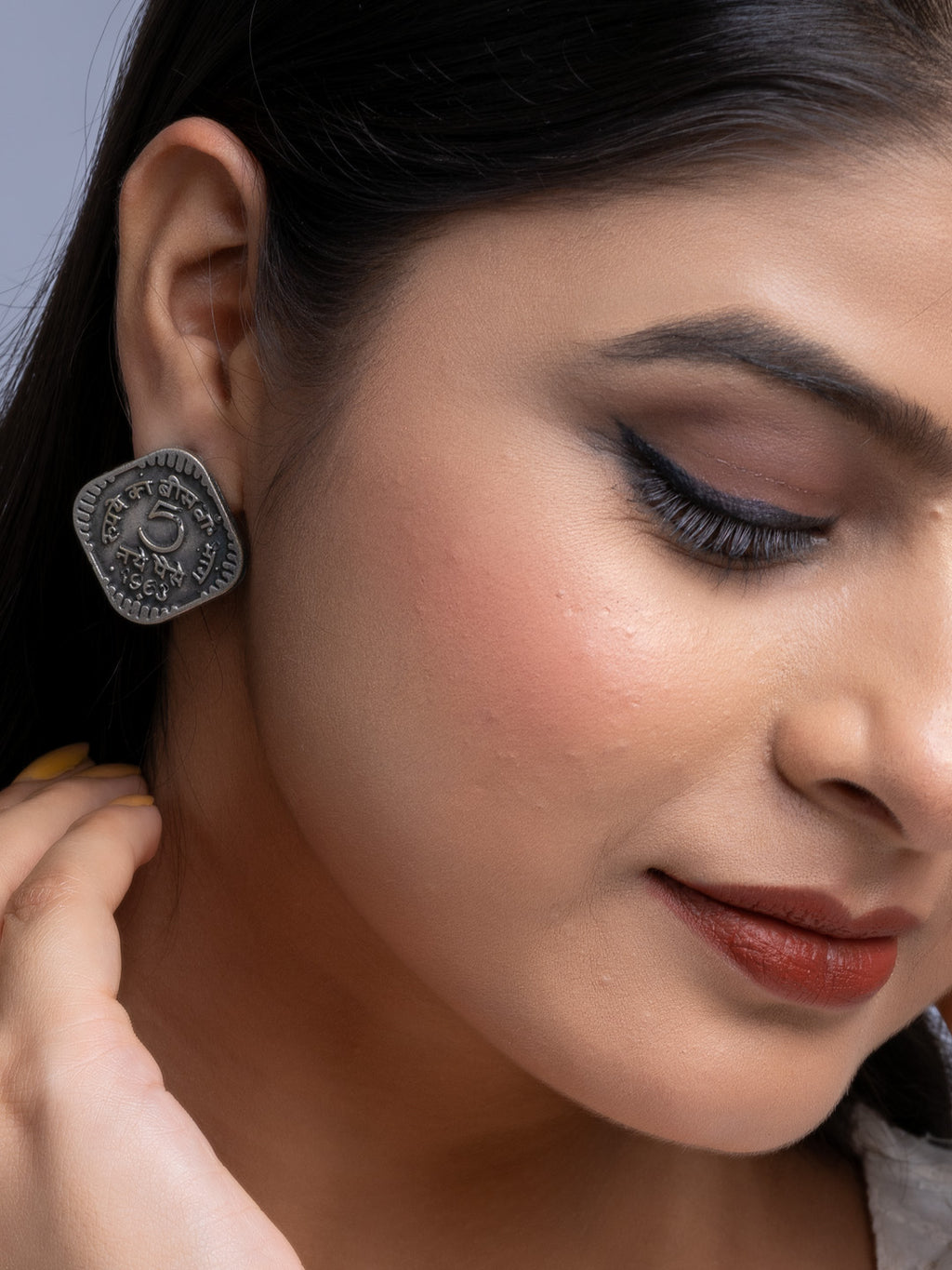 Close-up of a woman wearing oxidised silver earrings with intricate design by LOOK AND ADORN