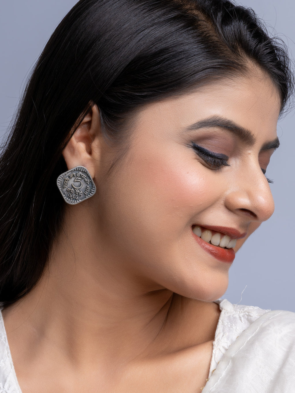 Close-up of woman wearing oxidised silver earrings with intricate design by LOOK AND ADORN