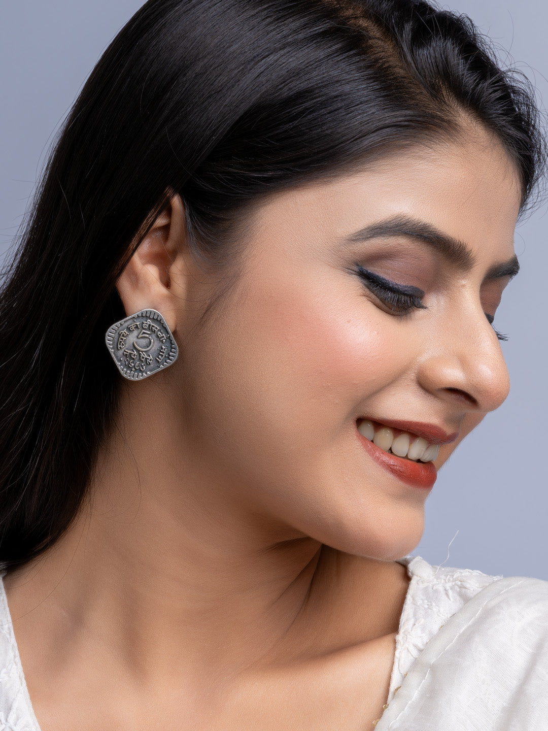 Close-up of woman wearing oxidised silver earrings with intricate design by LOOK AND ADORN