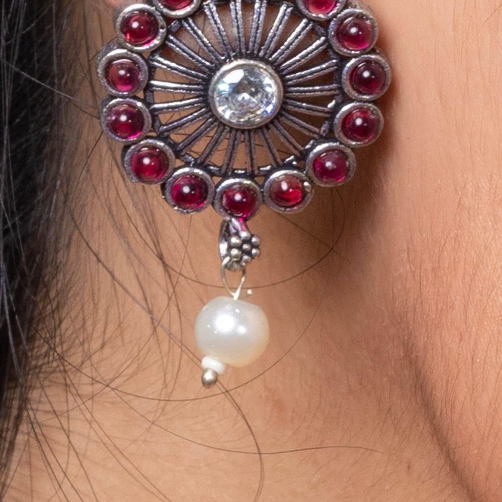 Oxidised silver stud earring with red stones and a pearl hanging design for a stylish look