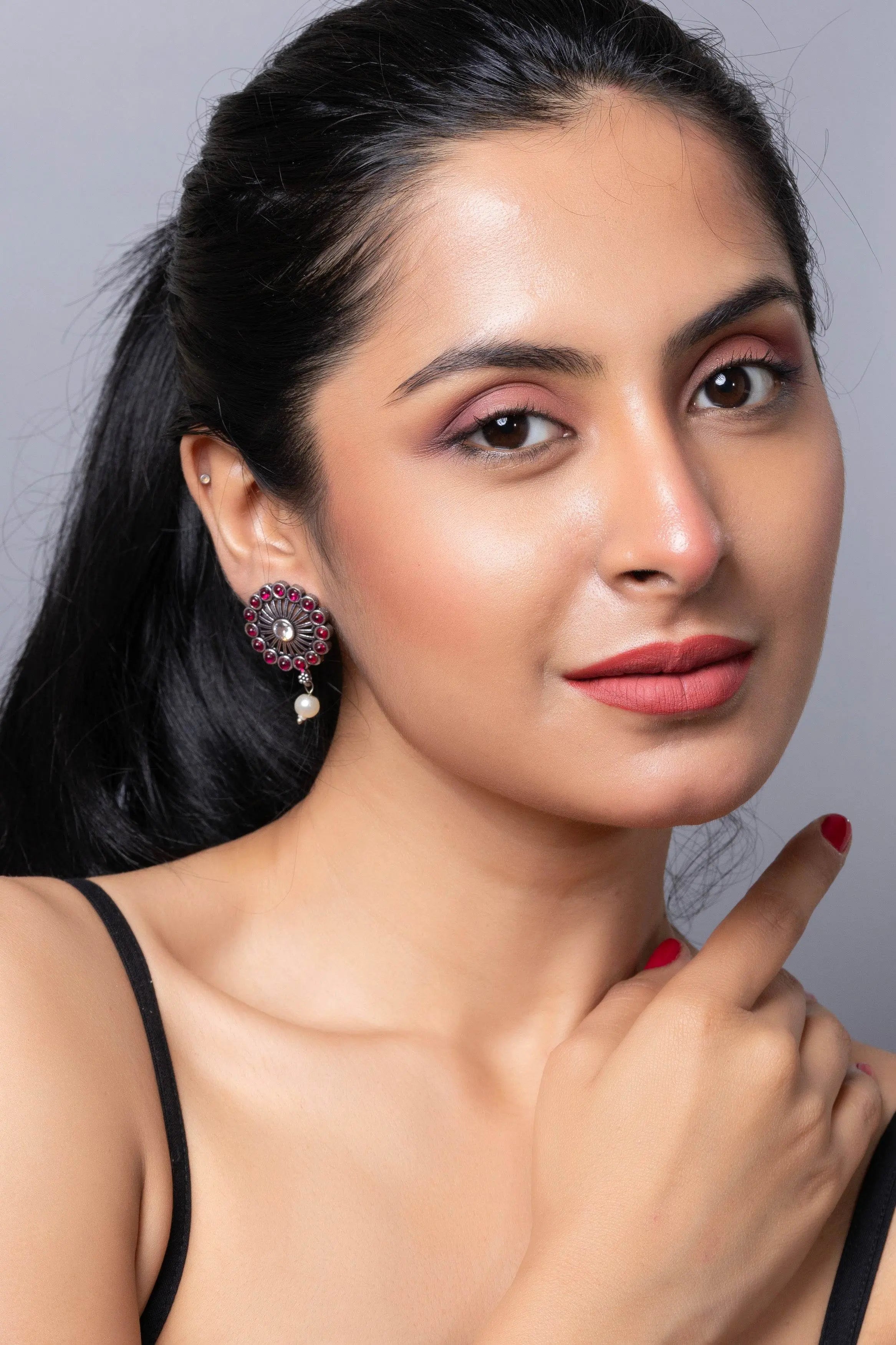 Elegant oxidised silver stud earring with intricate design, model showcasing the jewelry in a stylish pose