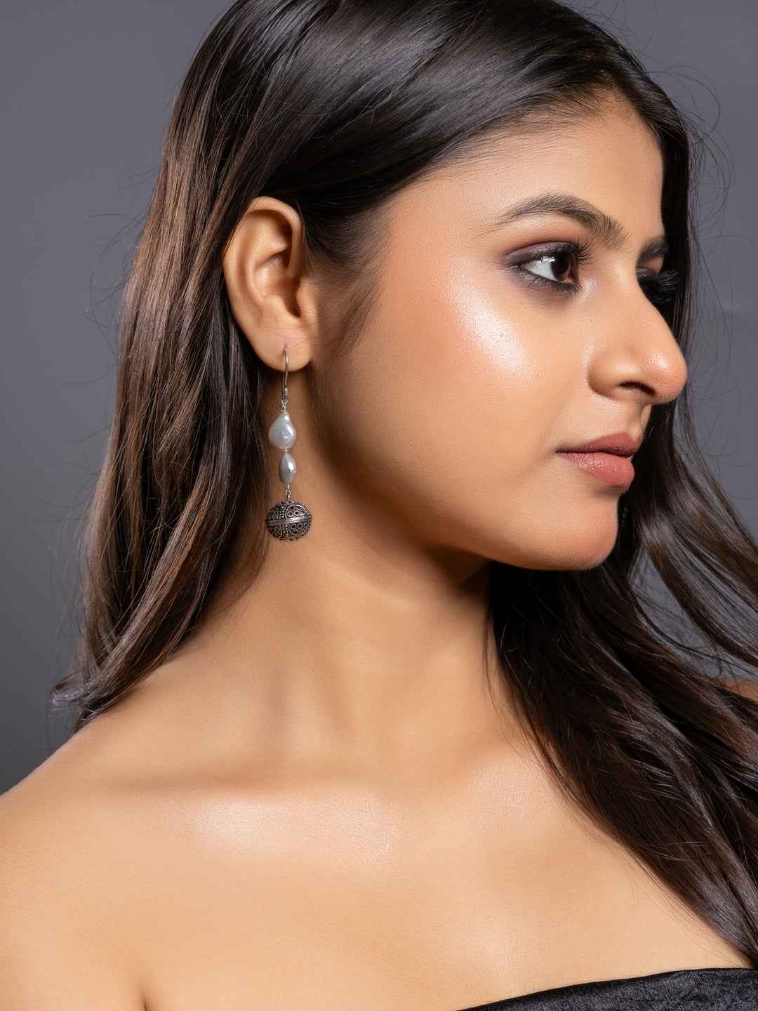 Silver pearl earrings featuring a delicate design with gray pearls and intricate metal detailing