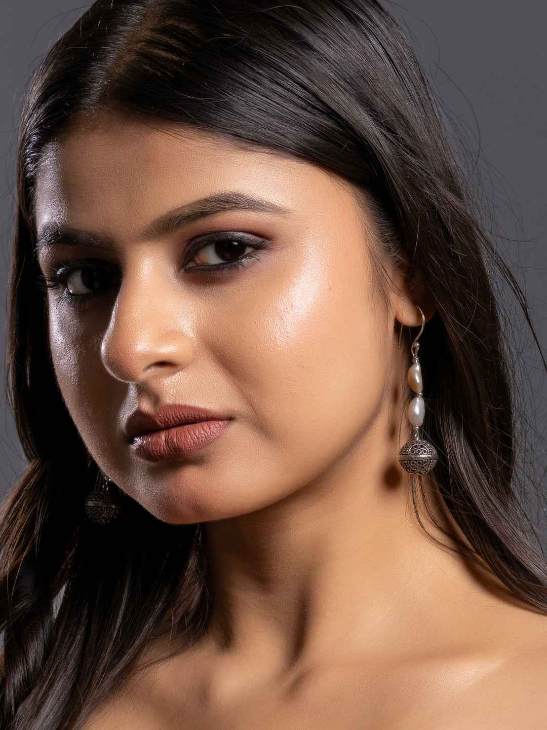 Stylish pearl earrings with a delicate silver design featuring two lustrous pearls