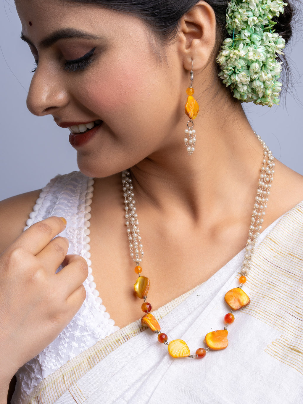 LOOK AND ADORN handmade mother of pearl necklace set with orange and pearl beads worn by woman in traditional attire