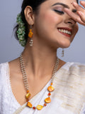 Elegant handmade mother of pearl necklace set featuring orange and pearl beads worn with traditional attire