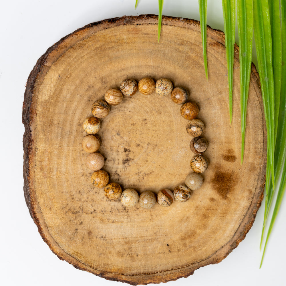 LOOK AND ADORN Astro-Gemstone Bracelet in Earthy Tones on a Wooden Surface