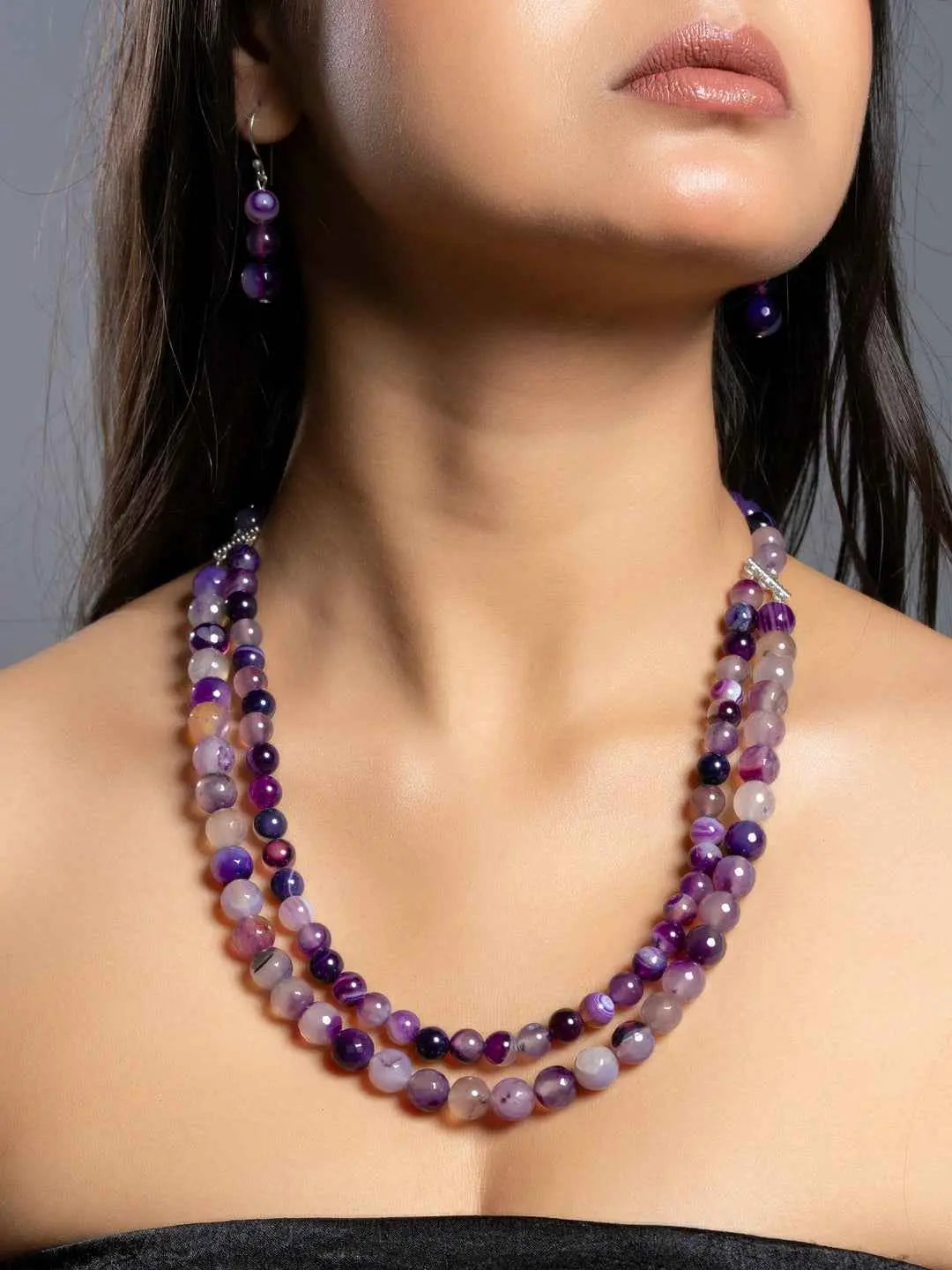 Elegant three-layer purple onyx necklace set with matching earrings, showcasing vibrant purple hues