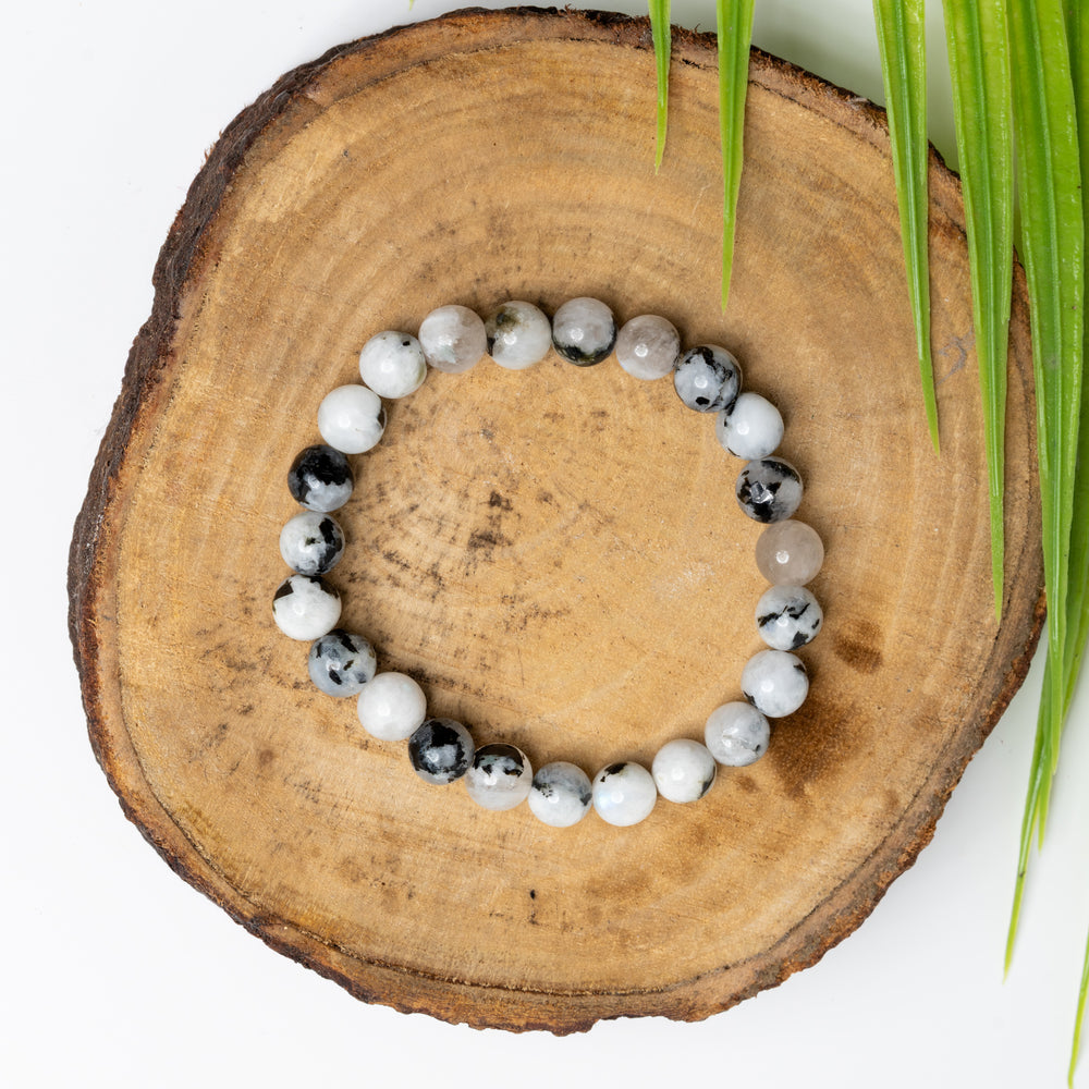 LOOK AND ADORN rainbow moonstone bracelet with a unique design featuring various gemstones on a wooden surface