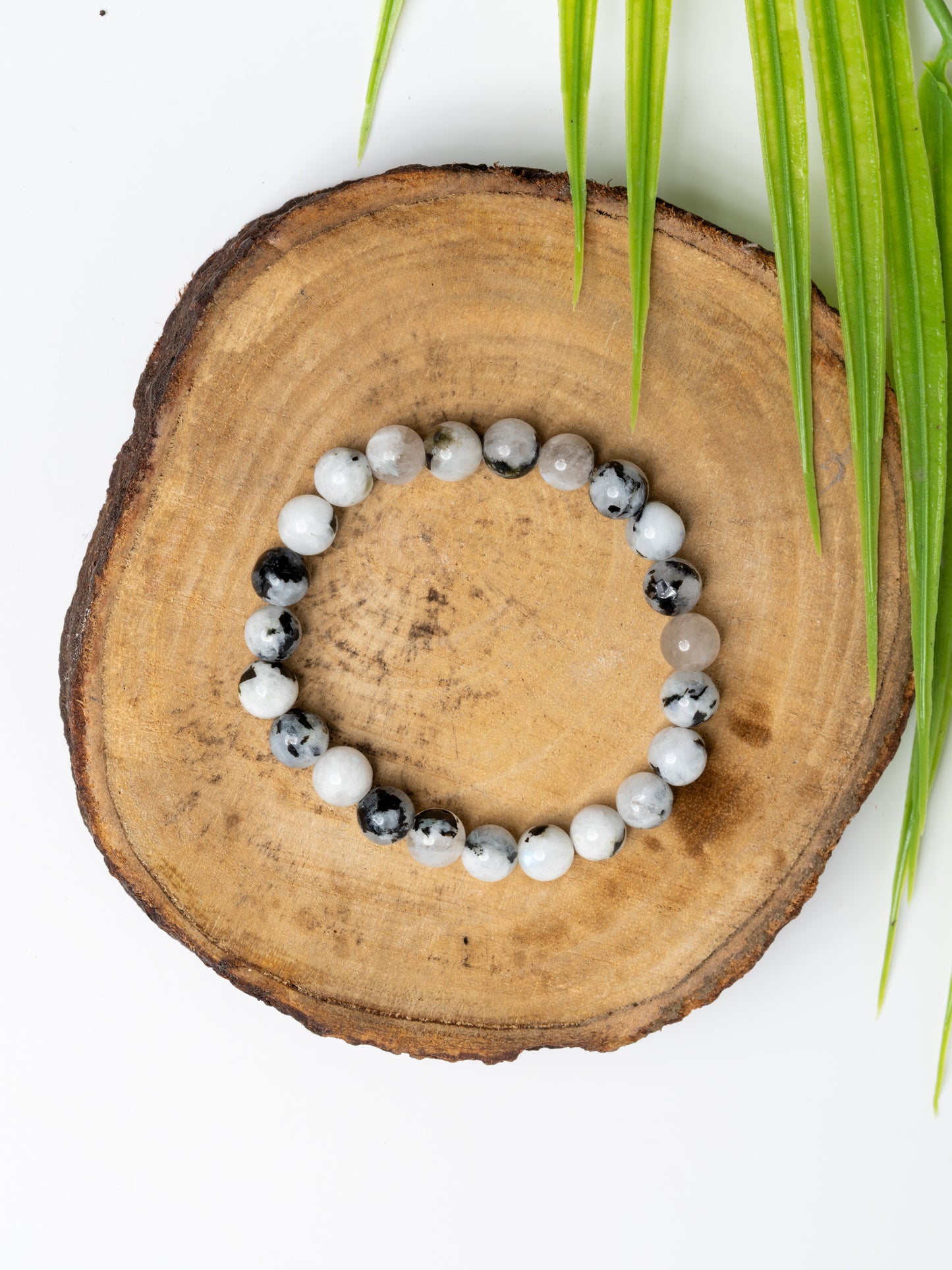 LOOK AND ADORN rainbow moonstone bracelet with a unique design featuring various gemstones on a wooden surface