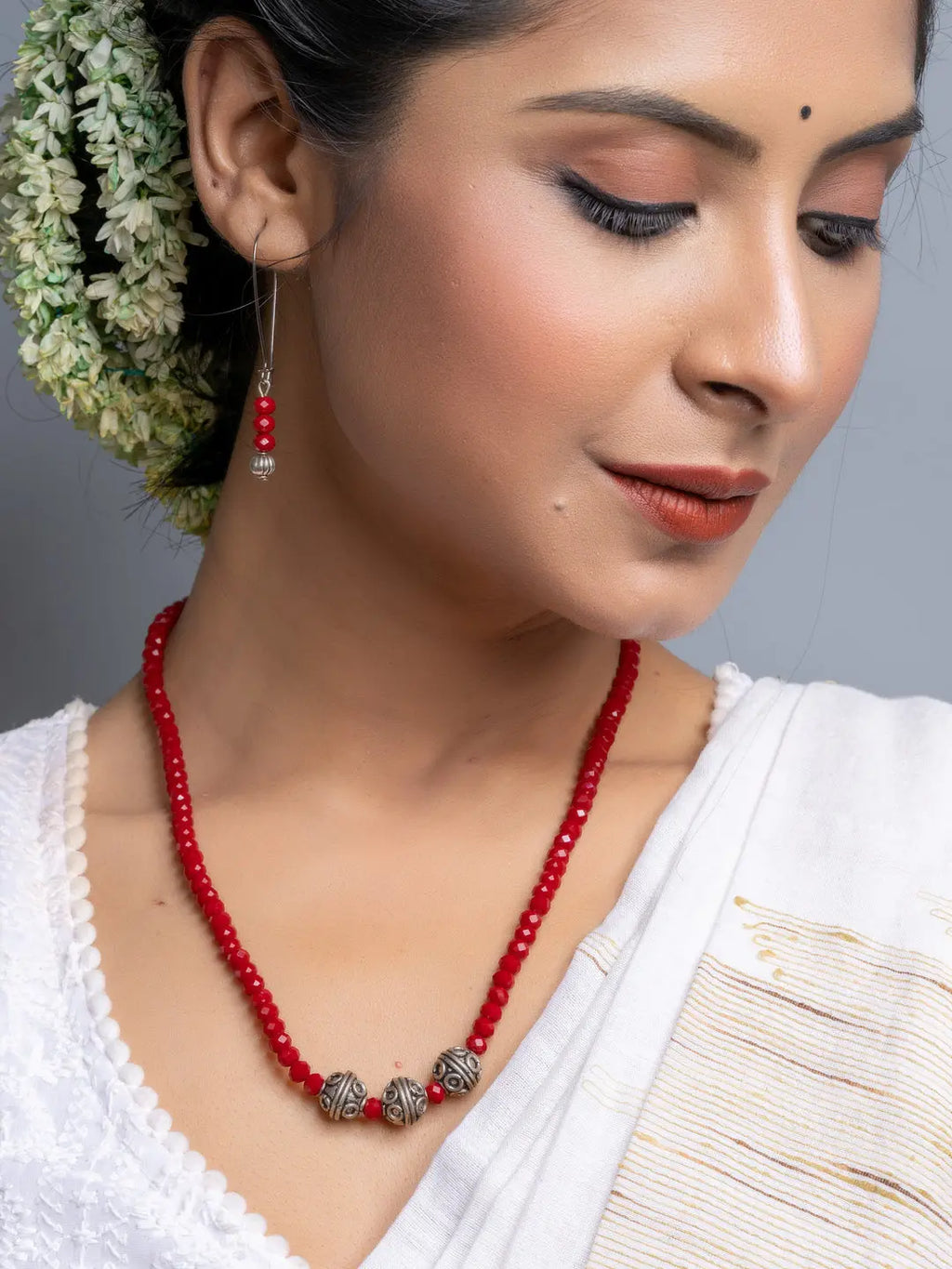 Red Crystal Necklace Set featuring handmade red beads and silver accents worn by a woman in traditional attire