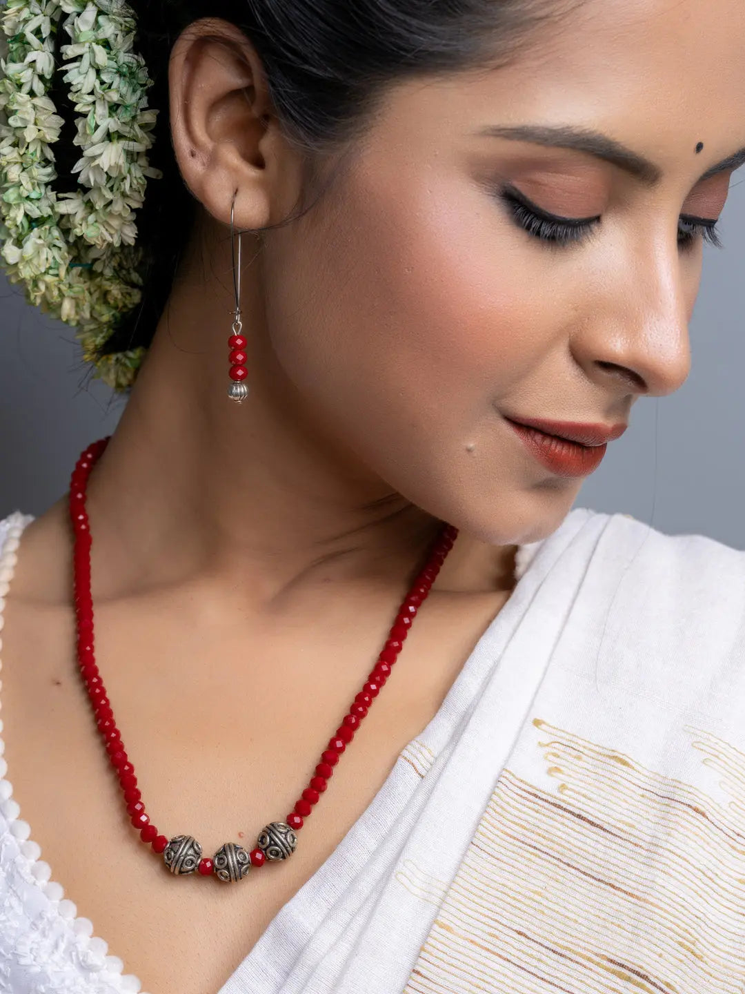 Handmade Red Crystal Necklace Set featuring red beads and silver accents worn with traditional attire