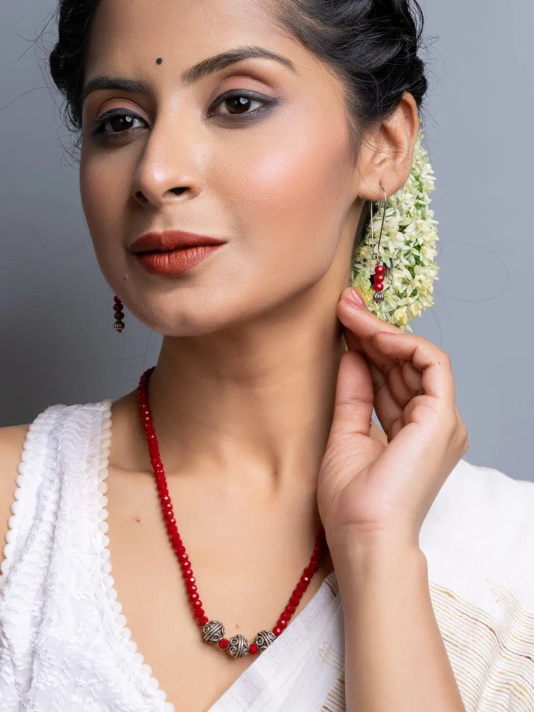 Woman wearing handmade Red Crystal Necklace Set with matching earrings and traditional attire