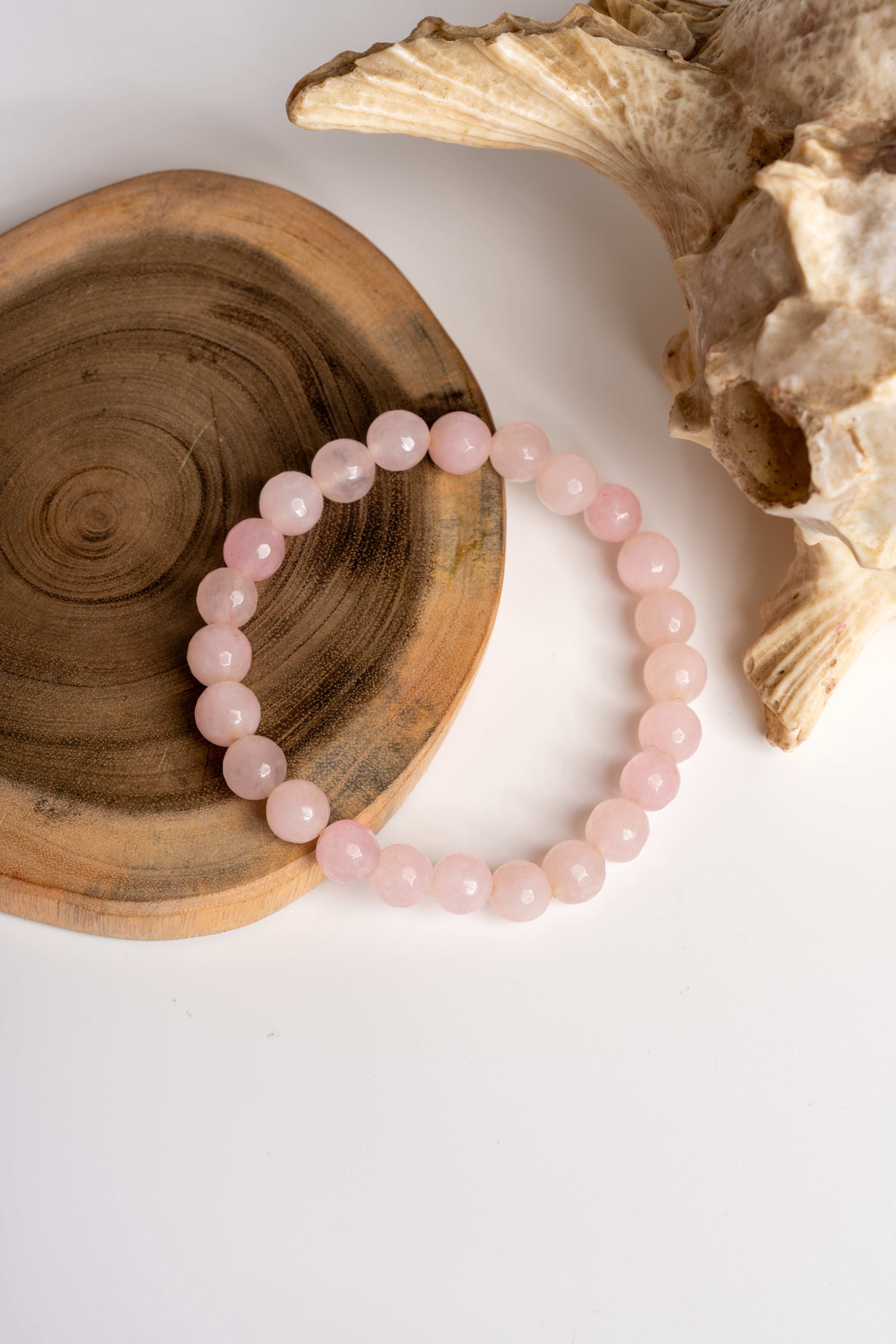 Elegant rose quartz stone bracelet on a wooden surface for charming accessory lovers