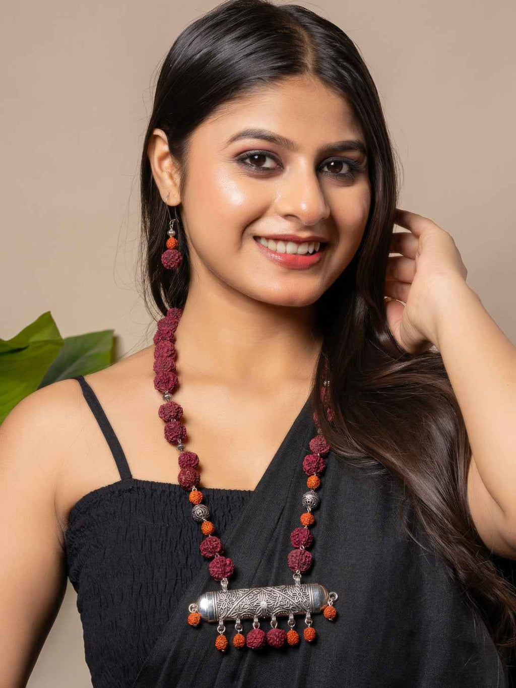 Handmade rudraksh necklace set with maroon beads and silver accents, styled elegantly for a chic look.