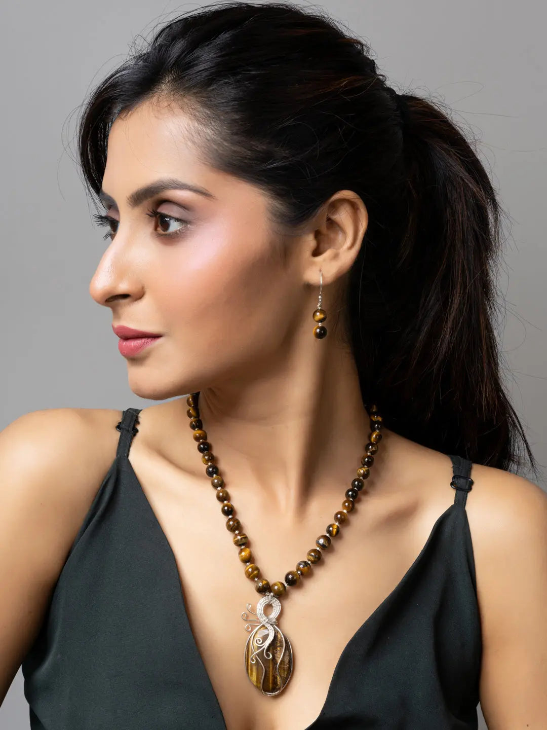 Handmade tiger eye necklace with matching earrings worn by woman in black top