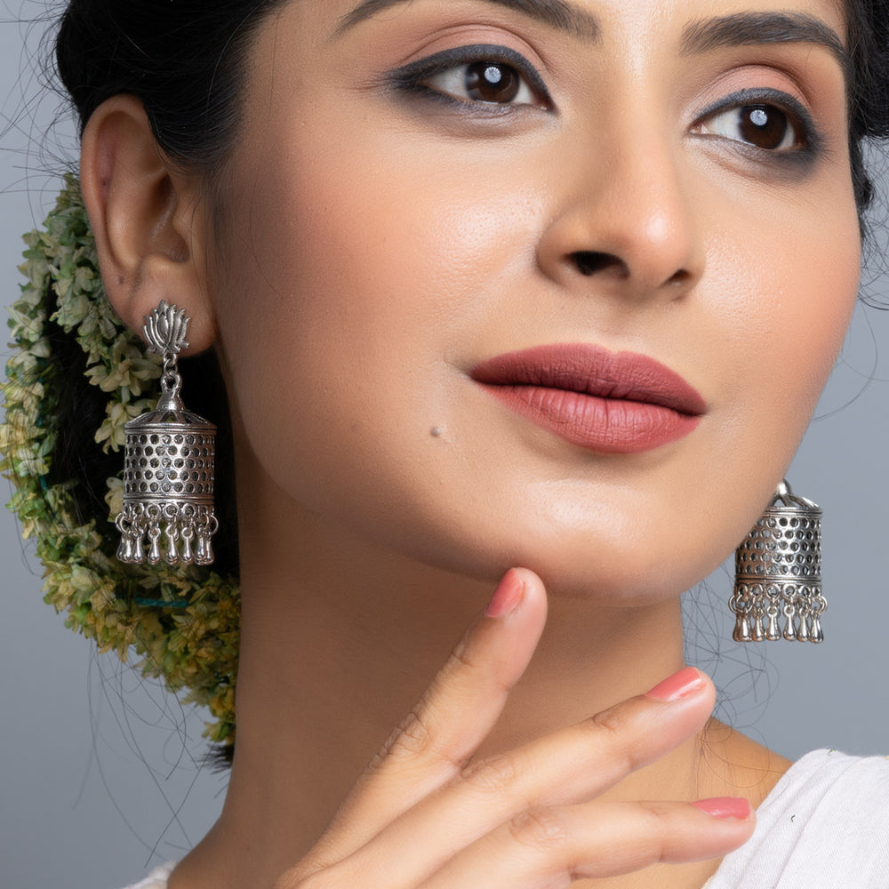 Oxidised silver jhumka earrings worn by woman with traditional hairstyle and makeup