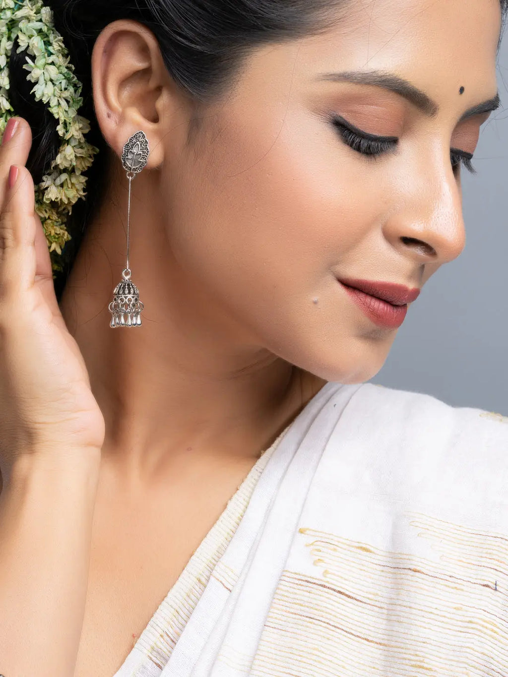 Oxidised silver jhumka earrings by LOOK AND ADORN worn by woman with traditional white saree