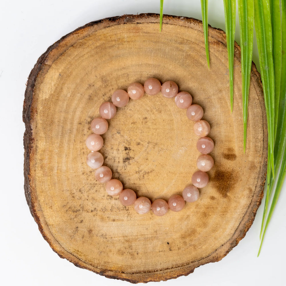 Sunstone Bracelet by LOOK AND ADORN designed for you on a wooden surface surrounded by greenery
