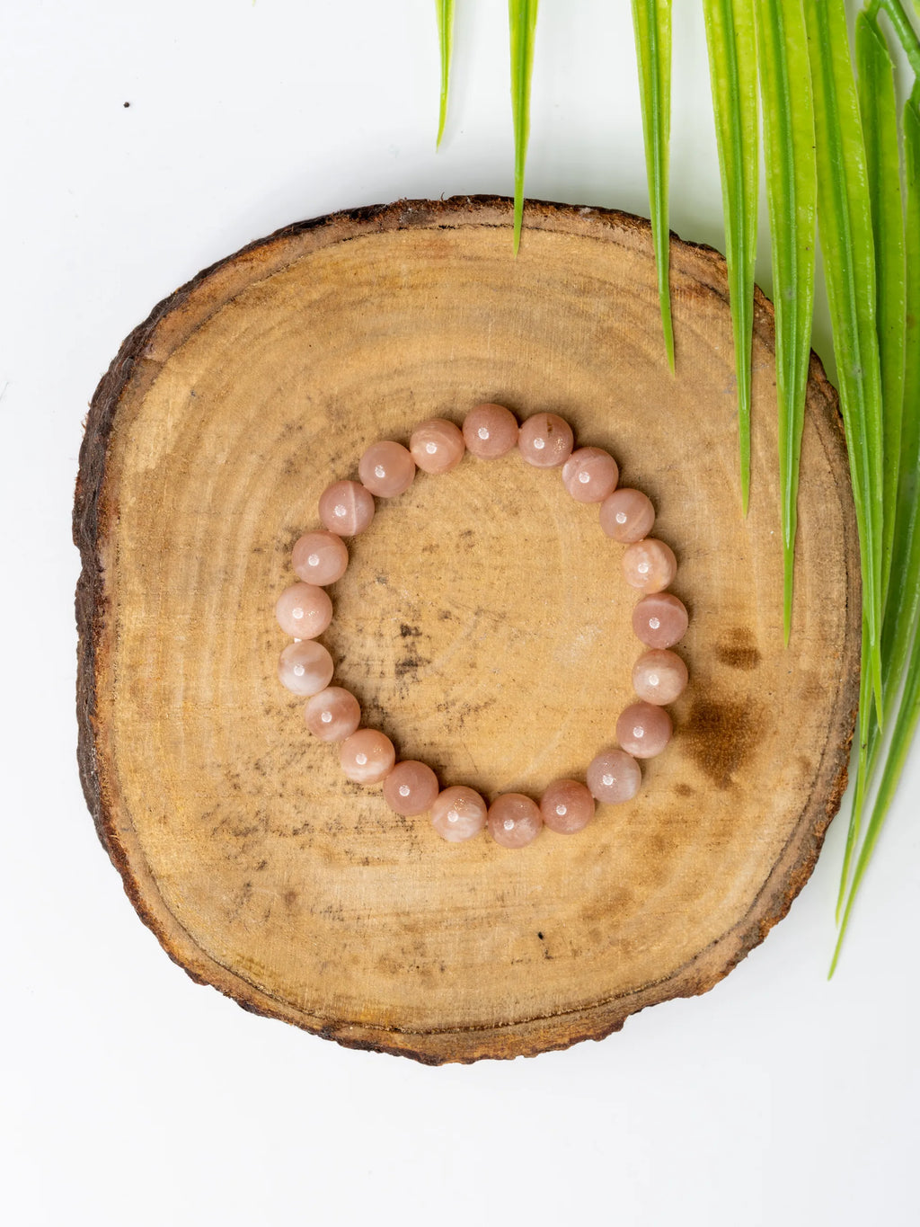 Sunstone Bracelet by LOOK AND ADORN designed for you on a wooden surface surrounded by greenery