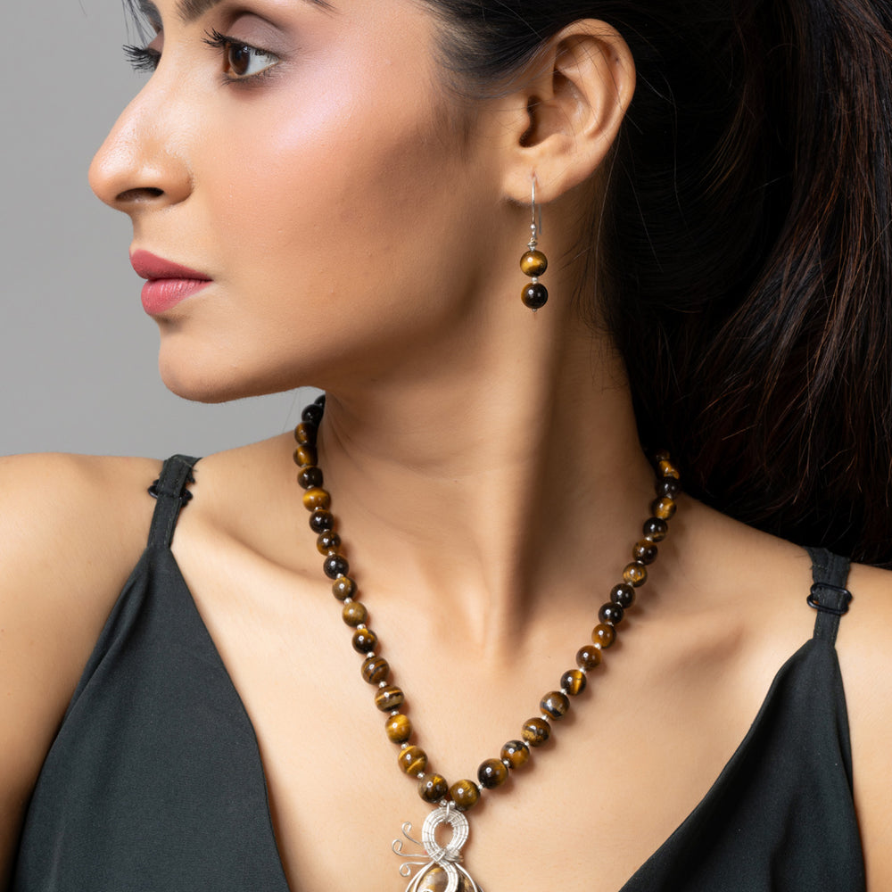Woman wearing handmade tiger eye necklace with matching earrings and pendant by LOOK AND ADORN
