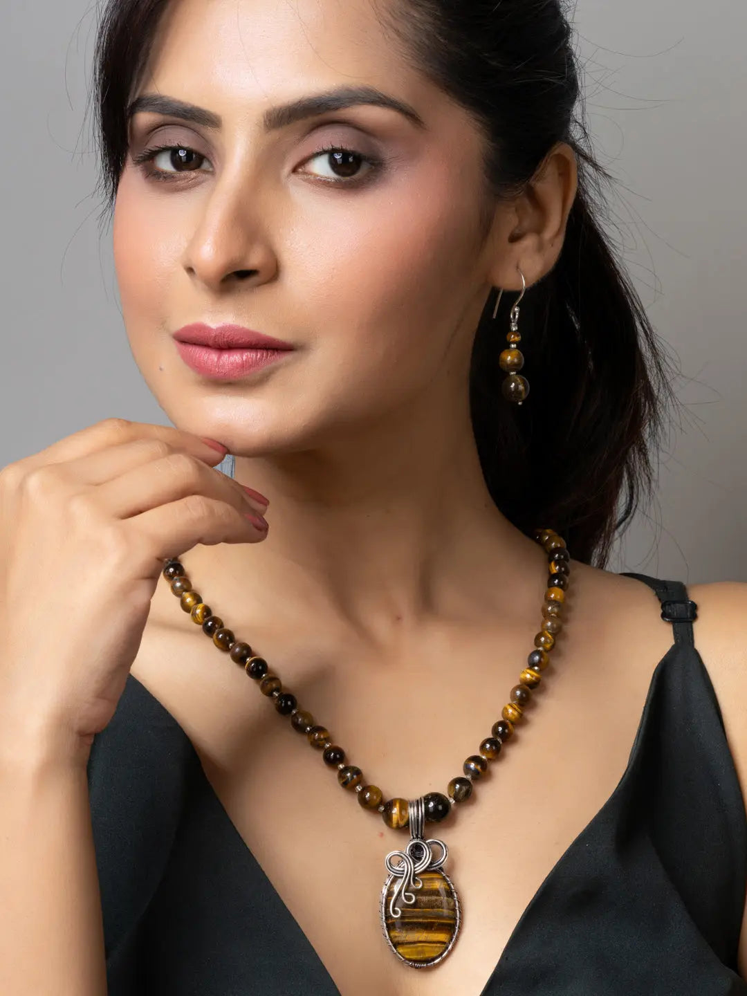 Handmade tiger eye necklace with matching earrings worn by a woman in a black top