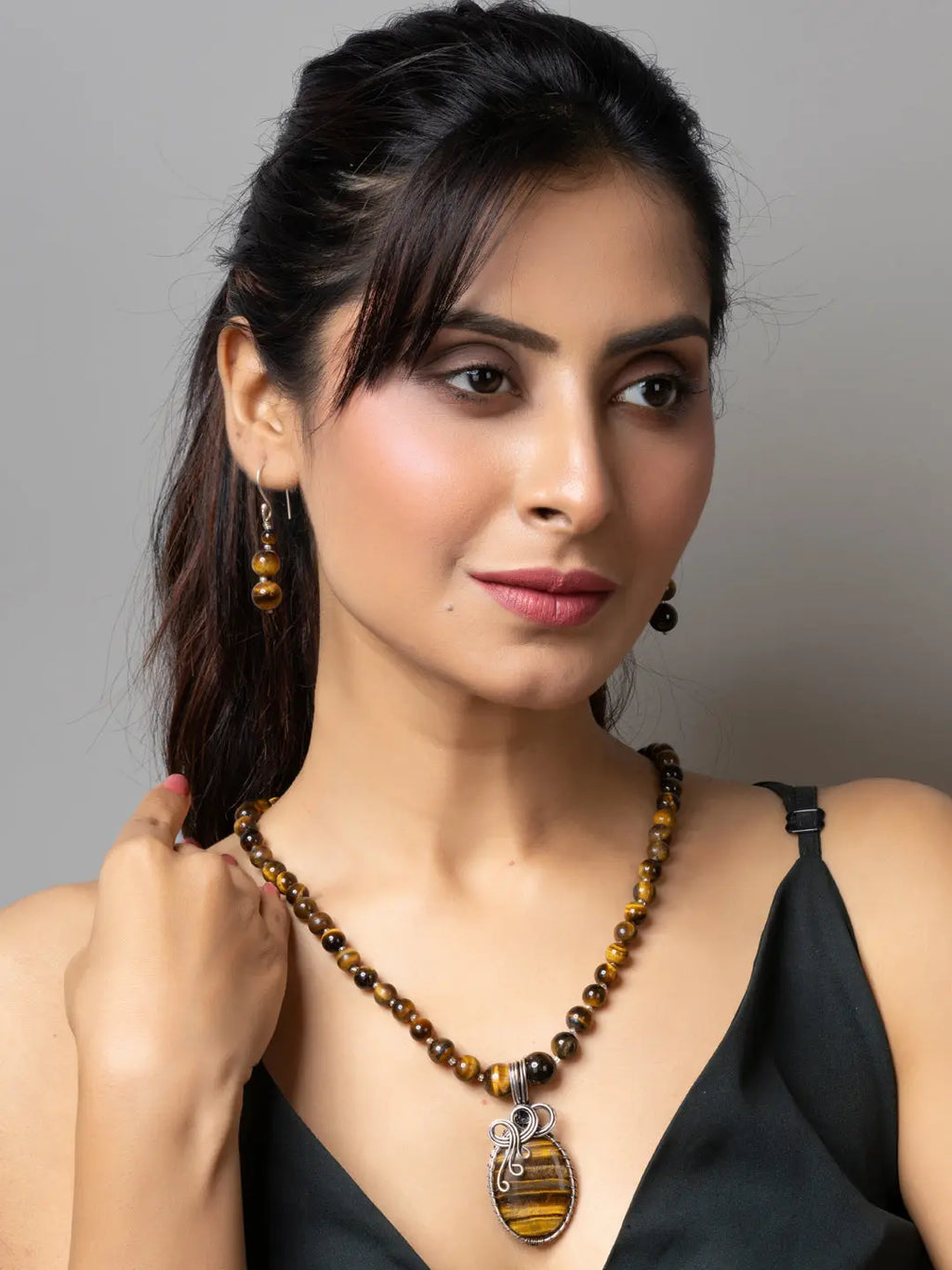 Handmade tiger eye necklace with silver pendant worn by woman in black top from LOOK AND ADORN