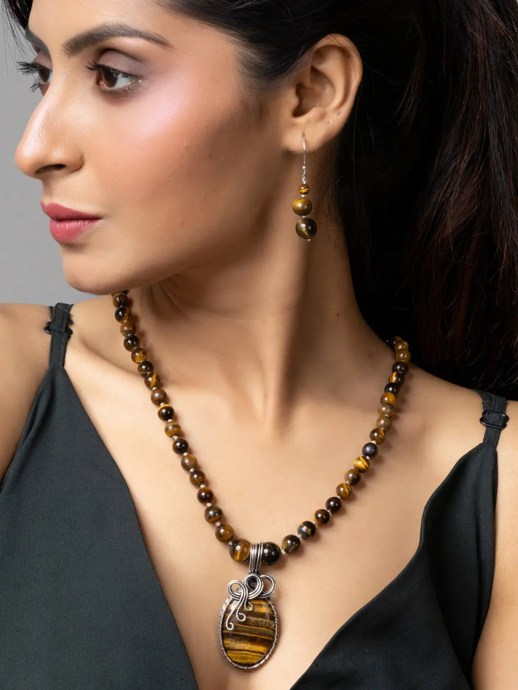 Handmade tiger eye necklace with matching earrings worn by woman in black top