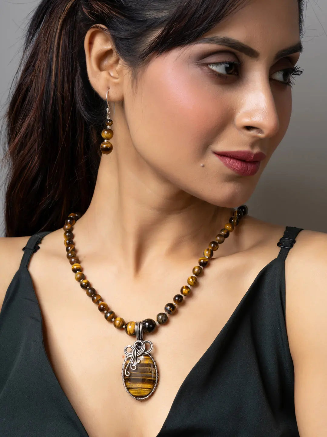 Handmade tiger eye necklace with matching earrings worn by woman in black sleeveless top