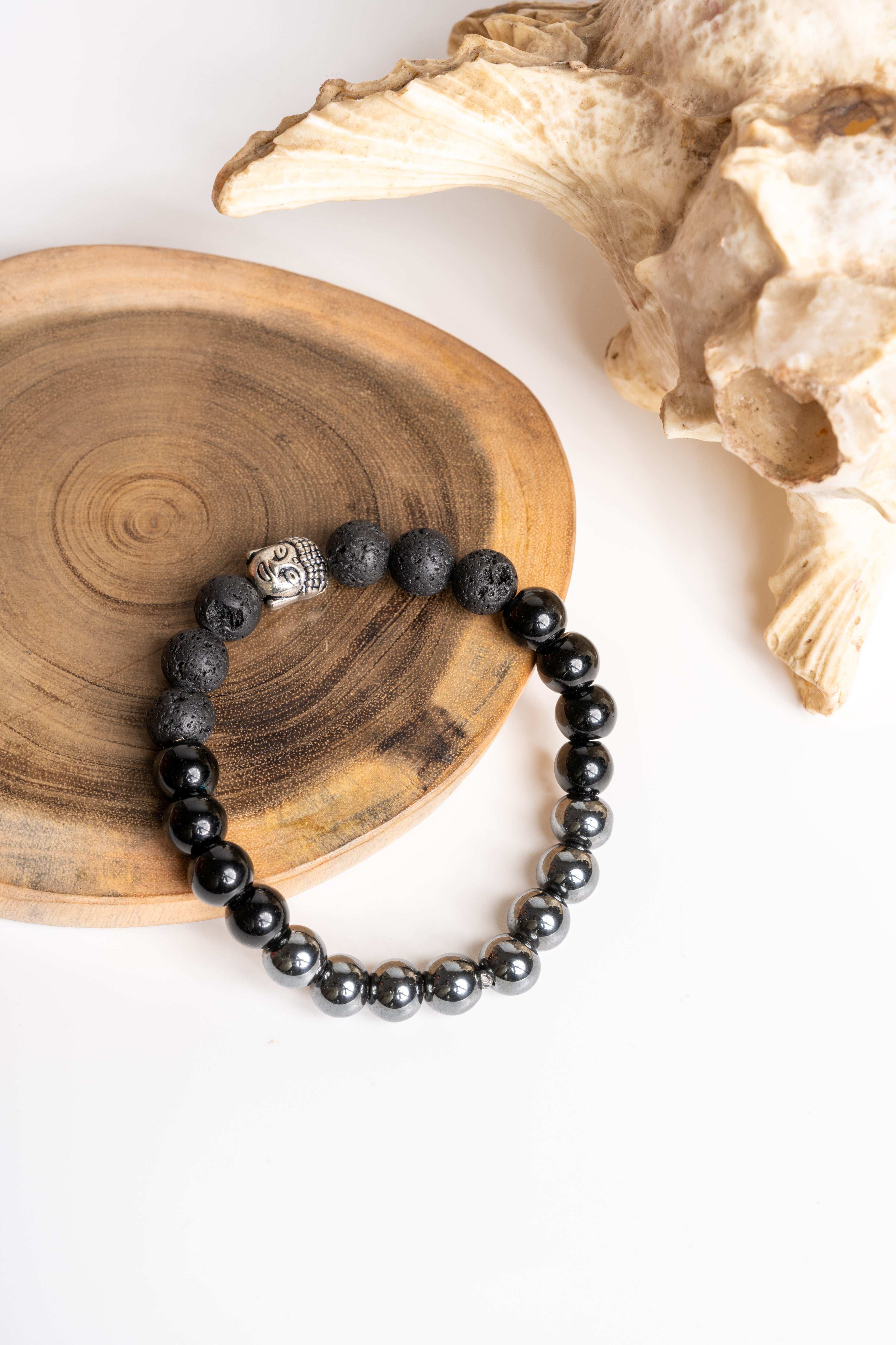 Triple protection Bracelet featuring black and gray gemstones on a wooden display