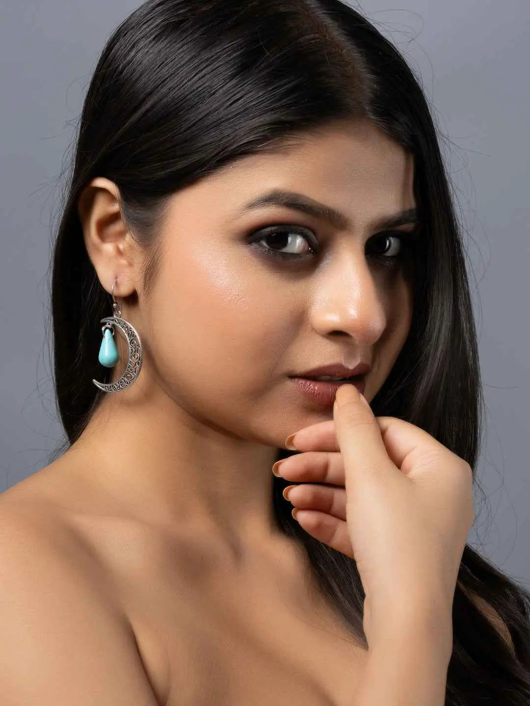 Handmade turquoise earrings with intricate silver detailing, showcasing a stylish boho design