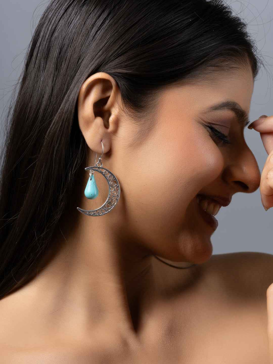 Handmade turquoise earrings with a silver crescent design and teardrop detail, perfect for stylish outfits