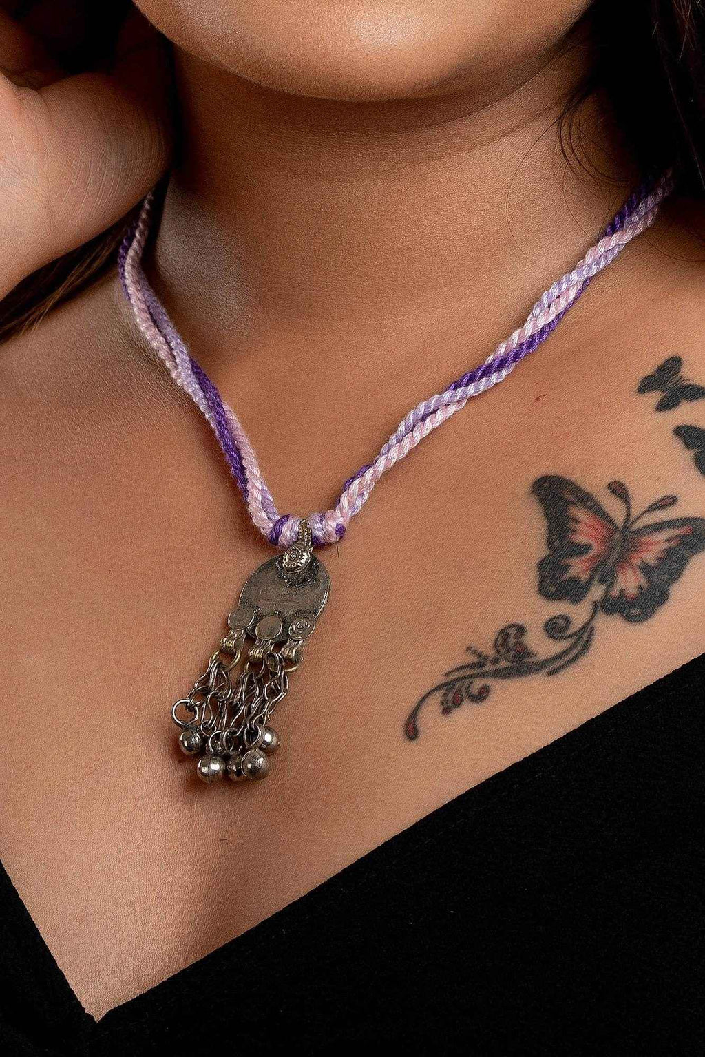 LOOK AND ADORN Afghani Necklace with silver pendant and purple braided cord worn on model's neck