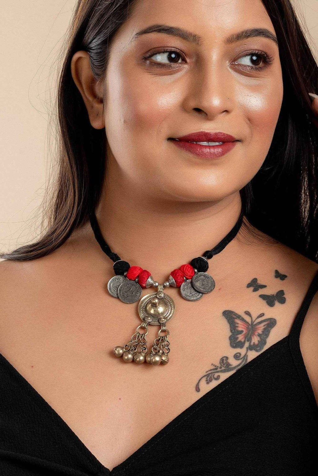 Woman wearing an Afghani Necklace with coins and red thread detailing from LOOK AND ADORN