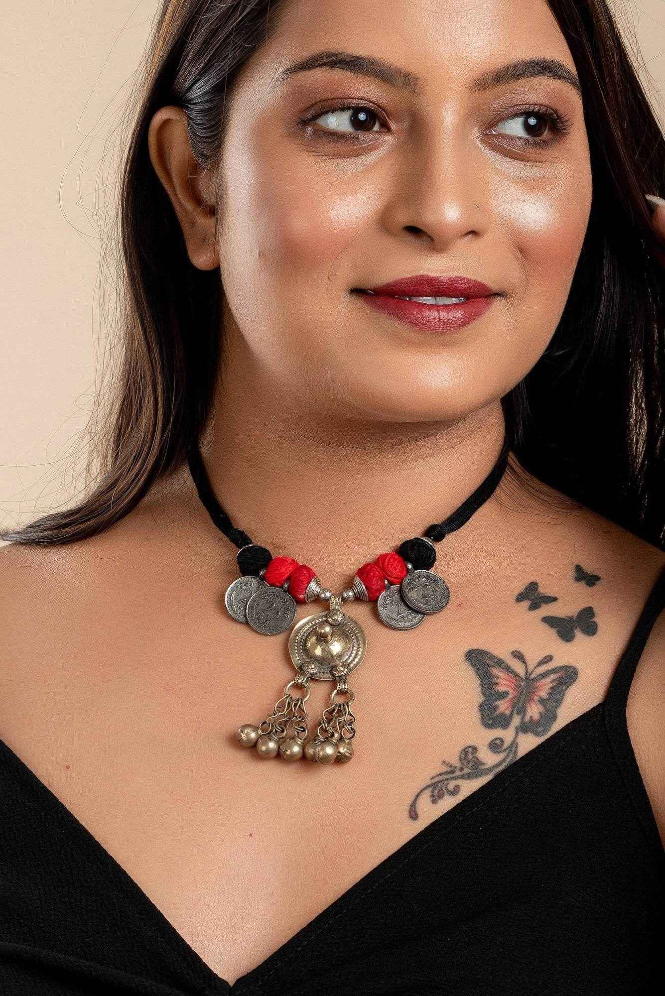 Woman wearing an Afghani Necklace with coins and red thread detailing from LOOK AND ADORN