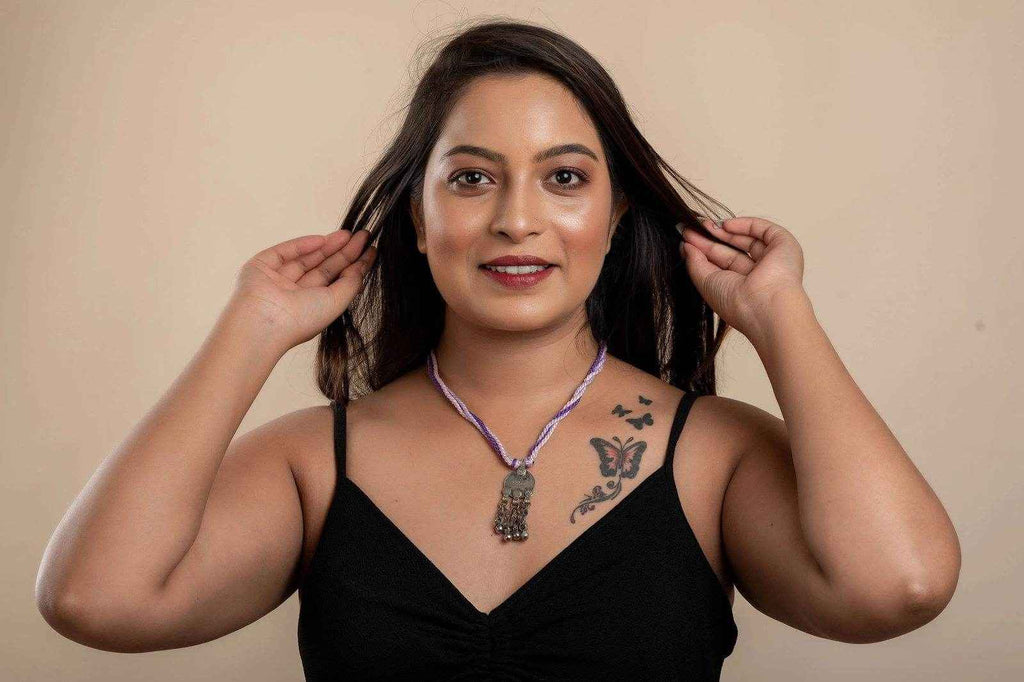 Woman wearing a traditional Afghani Necklace with intricate silver pendant and purple cord