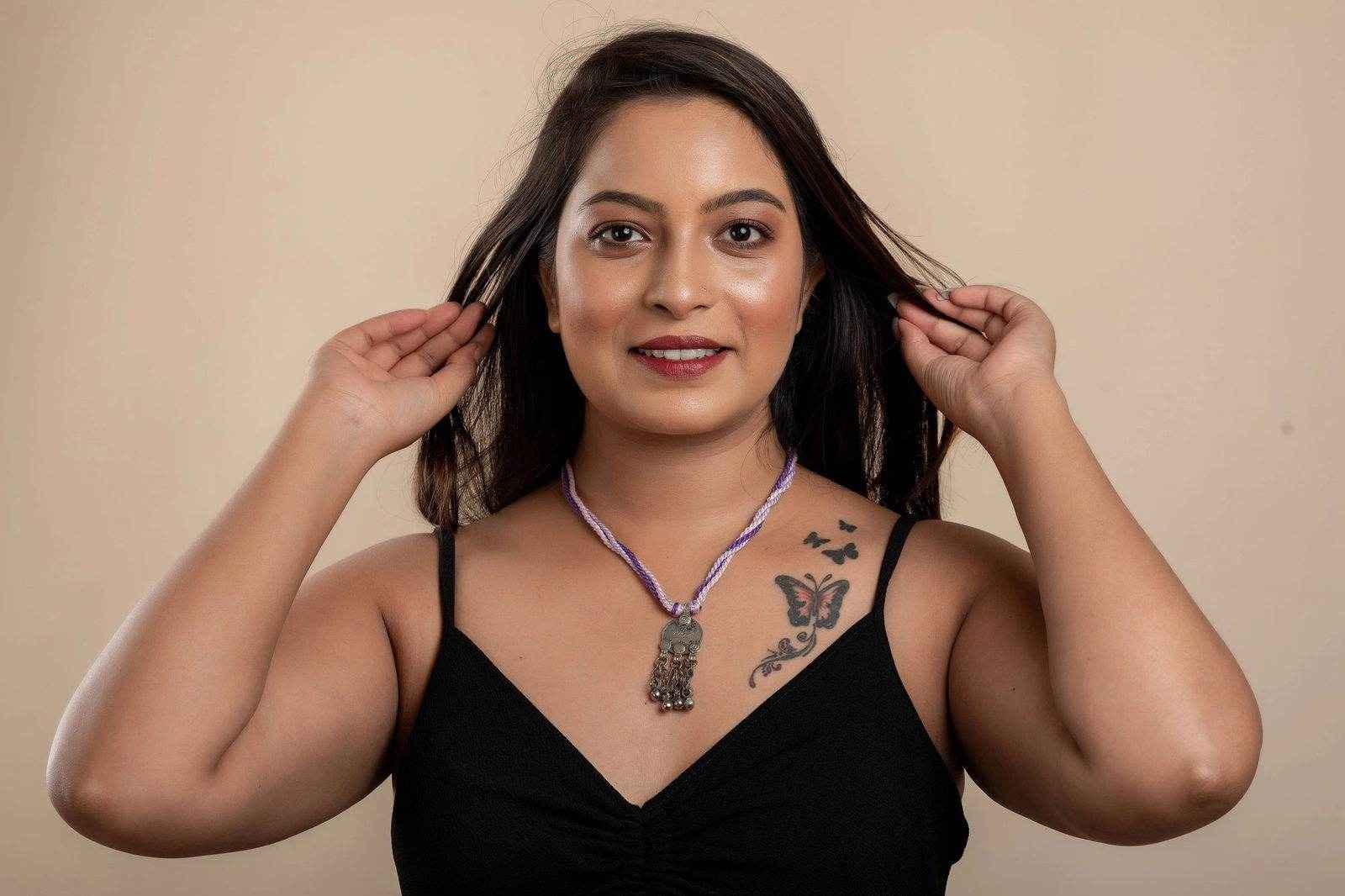 Woman wearing a traditional Afghani Necklace with intricate silver pendant and purple cord